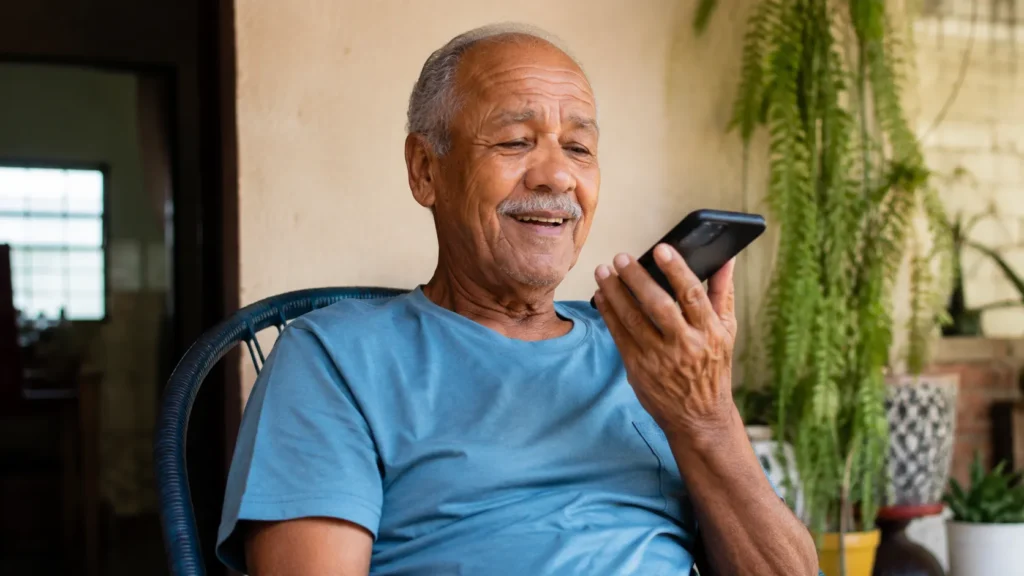 idoso usando aplicativos para idosos no celular com facilidade
